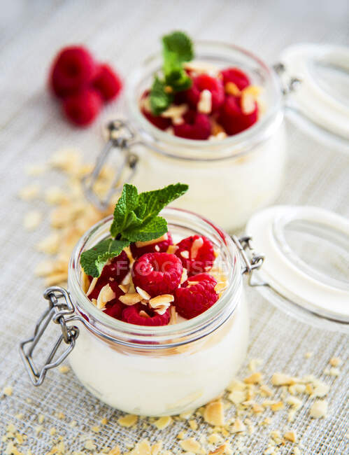 Served jar with yogurt full of fresh raspberries table — Stock Photo