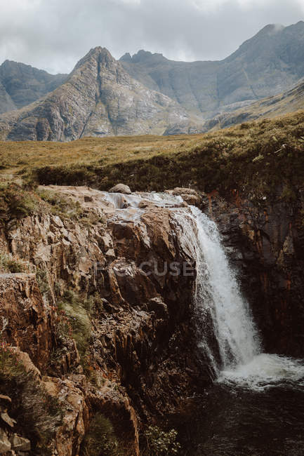 Vista mozzafiato sulle alte montagne nude e l'acqua che cade dalla roccia in Fairy Pool durante il giorno — Foto stock