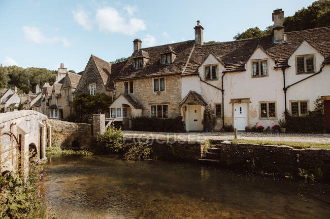Picturesque view of medieval village Castle Combe with white and gray stone buildings by river in Dorset on sunny day — Stock Photo