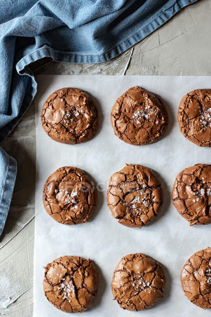 Von oben Zusammensetzung köstlicher Schokoladen-Brownie-Kekse auf weißem Pergament und blauem Handtuch — Stockfoto