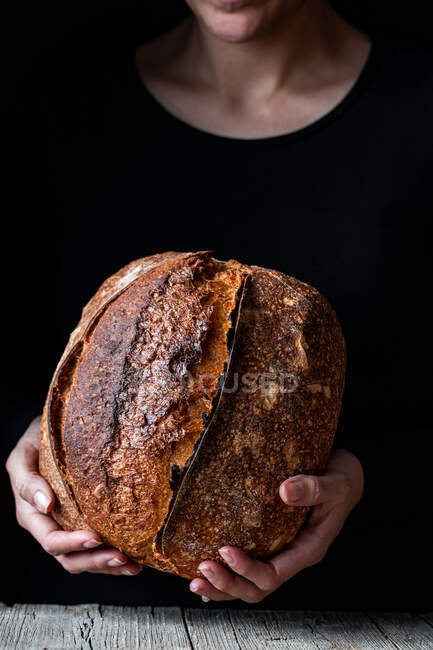 Personne méconnaissable montrant du pain frais — Photo de stock