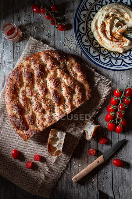 De cima pão de pidesi Ramazan colocado perto de tomates frescos e especiarias na mesa de madeira serrada — Fotografia de Stock