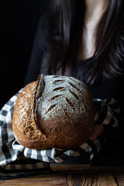 Неузнаваемый человек показывает свежий хлеб — стоковое фото