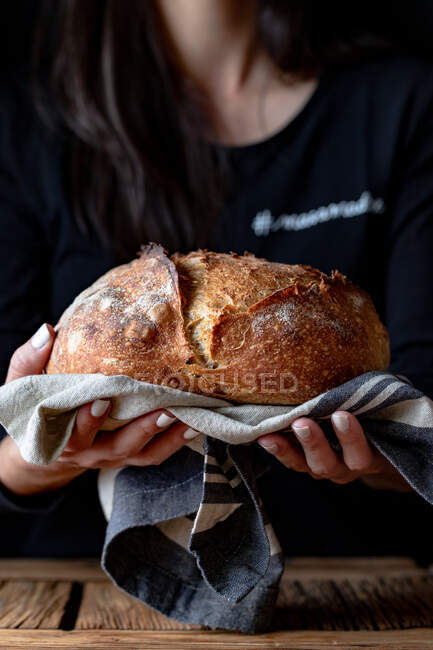 Unrecognizable person showing fresh bread — Stock Photo