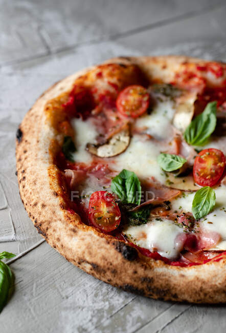 Delicious fresh summer pizza placed on timber table in rustic kitchen — Stock Photo