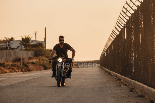 Brutal hombre conducir motocicleta en campo desierto carretera - foto de stock