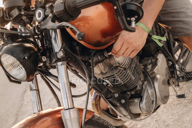 Чоловіча рука вмикає двигун вінтажного мотоцикла. — стокове фото