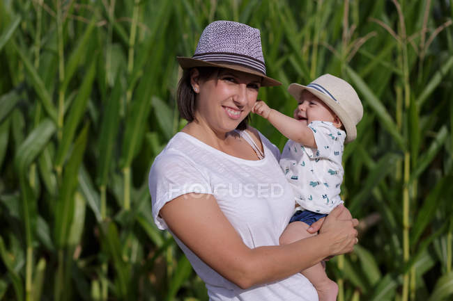 Adorável mãe e filho na mão desfrutando e rindo no campo — Fotografia de Stock