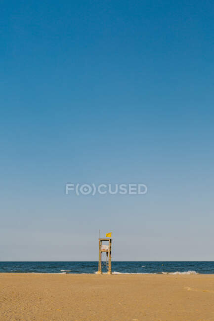 Beobachtungsbau am Sandstrand mit Radspuren am welligen Meer an bewölkten Tagen — Stockfoto