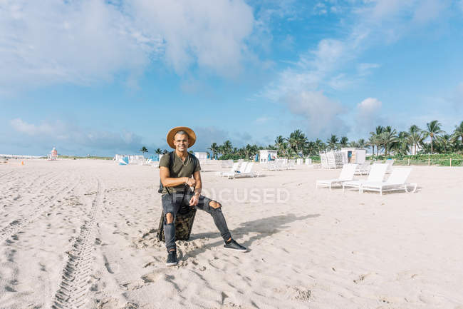 Bonito homem olhando para a câmera, posando na praia — Fotografia de Stock