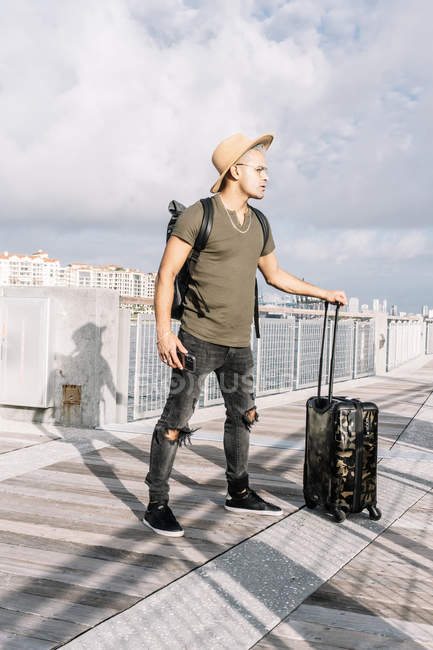 Фотографія повнометражного доброзичливого чоловіка, який їде в літню подорож і ходить з валізою — стокове фото