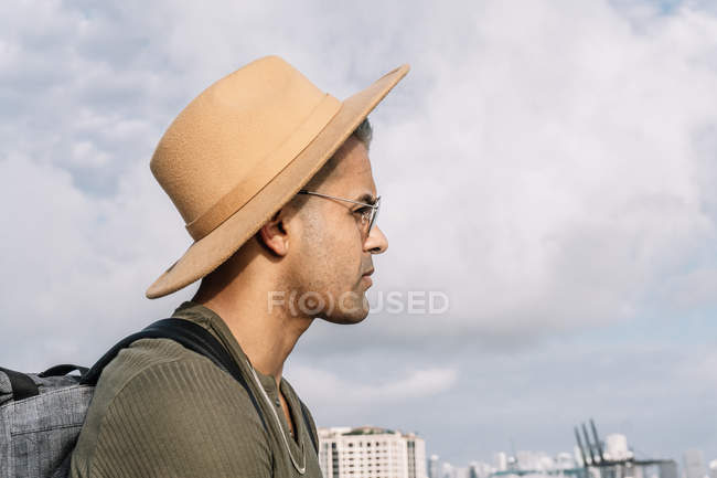 Vista lateral do homem com chapéu agradável e óculos olhando em frente — Fotografia de Stock