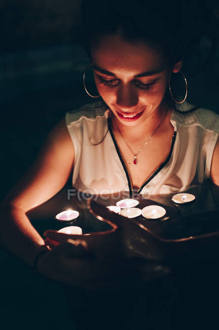 Woman swimming in pool with candles — Stock Photo
