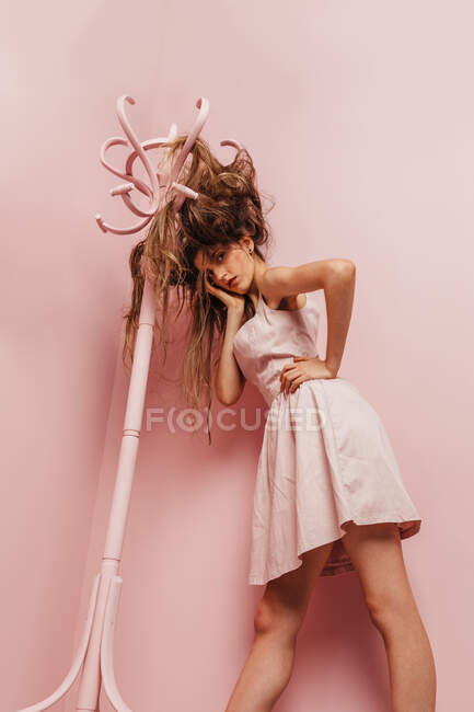 Front view of a teenage girl with tangled hairs on pink background — Stock Photo
