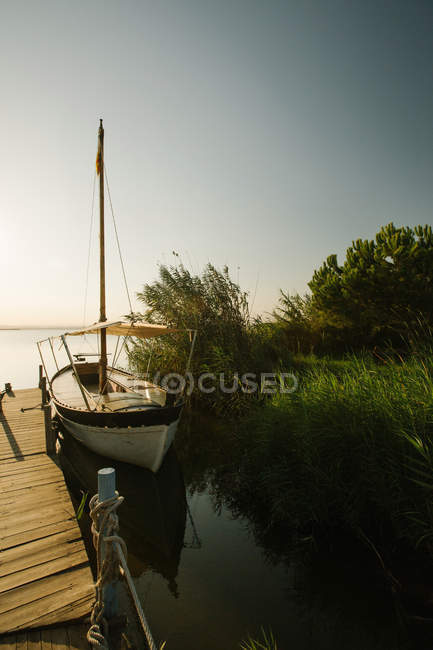 Moored boat by wooden pier — Stock Photo
