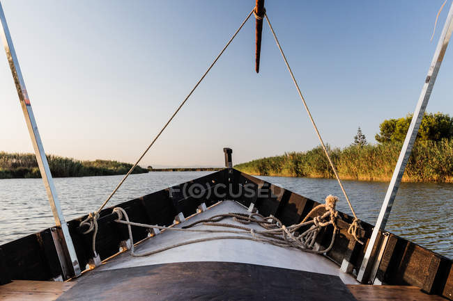 Fronte della barca cavalcando lungo il mare al crepuscolo — Foto stock
