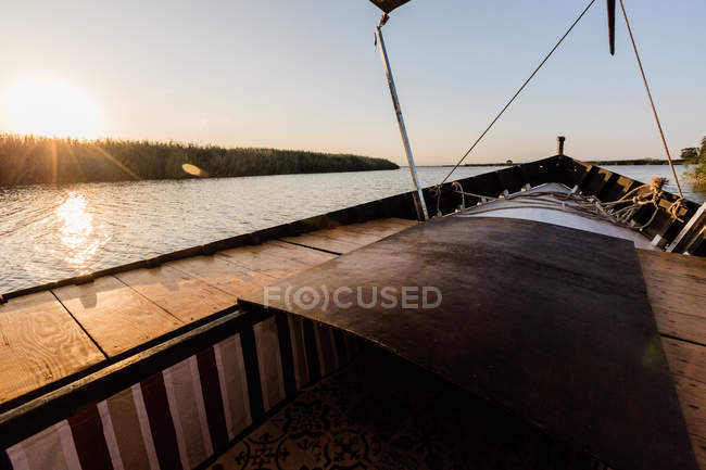 Frente del barco a caballo a lo largo del mar en el crepúsculo - foto de stock