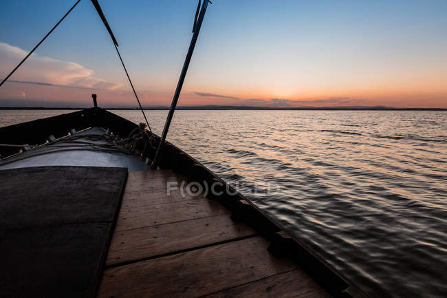 Avant du bateau chevauchant le long de la mer au crépuscule — Photo de stock