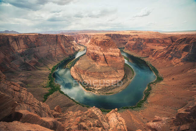 Scenic colorful rocky gorge with smooth lake in center on cloudy day in Horseshoe Bend, Arizona, USA — Stock Photo