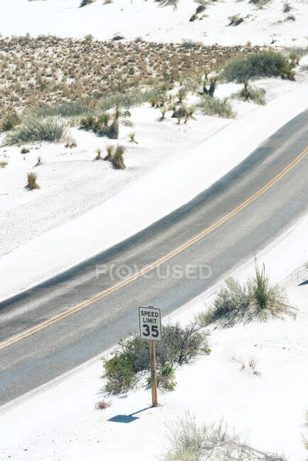 Desde arriba carretera rural en el campo polvoriento con línea eléctrica y cordillera remota en White Sands National Monument, Nuevo México, EE.UU. - foto de stock