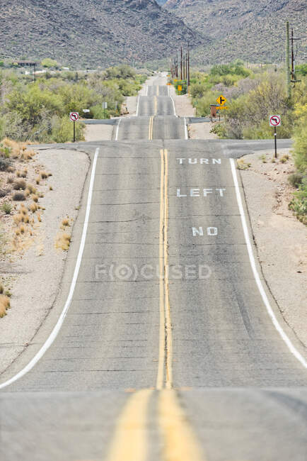 Estrada rural no campo empoeirado com linha de energia e cordilheira remota em Tucson, Arizona, EUA — Fotografia de Stock