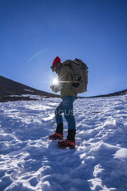 Unrecognizable person with backpack and hiking equipment contemplating while walking in a slope in daylight — Stock Photo