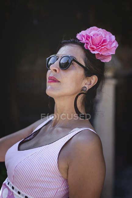 Ексцентрична жінка в барвисто-рожевому костюмі на літній вулиці — стокове фото