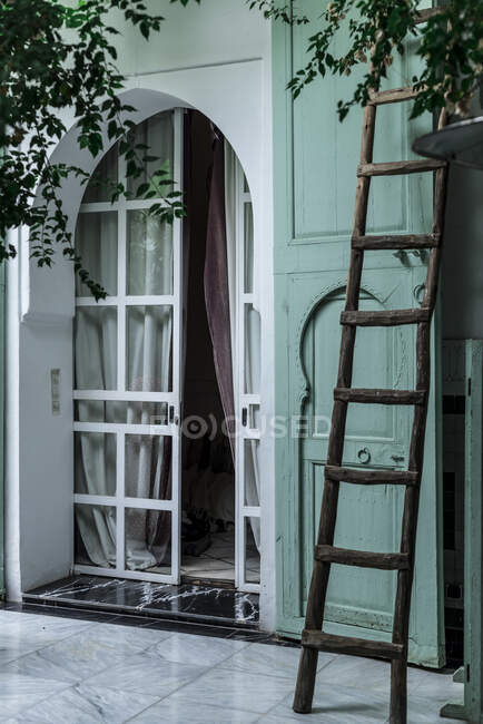 Old wooden ladder located near entrance of traditional Arabic building with green walls on street of Marrakesh, Morocco — Stock Photo