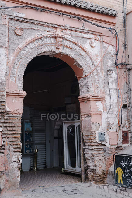 Crumbling arch of aged Arabic building on street of Marrakesh, Morocco — Stock Photo