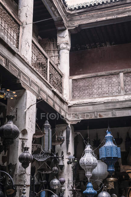 Verschiedene traditionelle arabische Laternen hängen im schäbigen Innenhof eines alten Gebäudes in Marrakesch, Marokko — Stockfoto