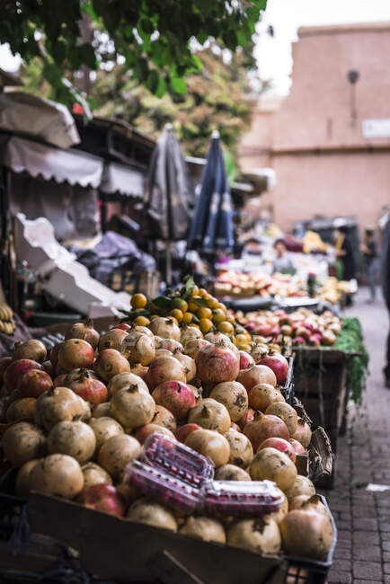 Puestos con frutas frescas y maduras situados en el mercado callejero de Marrakech, Marruecos - foto de stock
