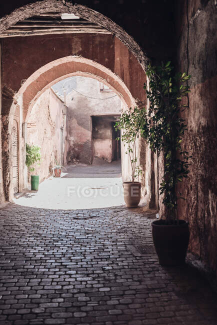 Paved path going through weathered archway on sunny day on street of Marrakesh, Morocco — Stock Photo