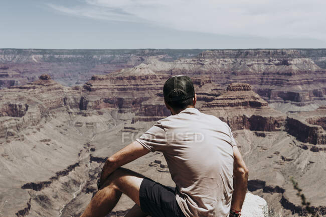 Guardare il turista in piedi sul bordo del pittoresco canyon — Foto stock