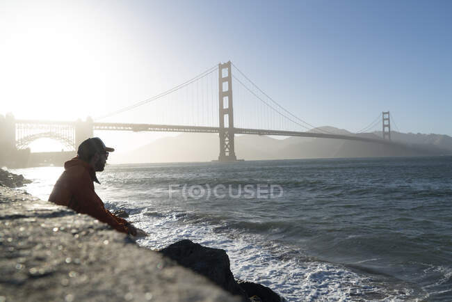 Turista contemplando el puente escénico en la tranquila bahía - foto de stock