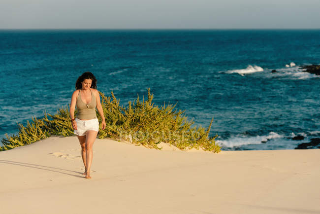 Tanned woman white shorts sandy shore in Fuerteventura, Las Palmas, Spain — seaside, - Stock Photo #313124980