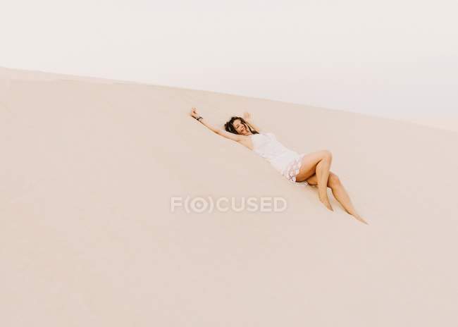 Жінка лежить на піску в пустелі — стокове фото