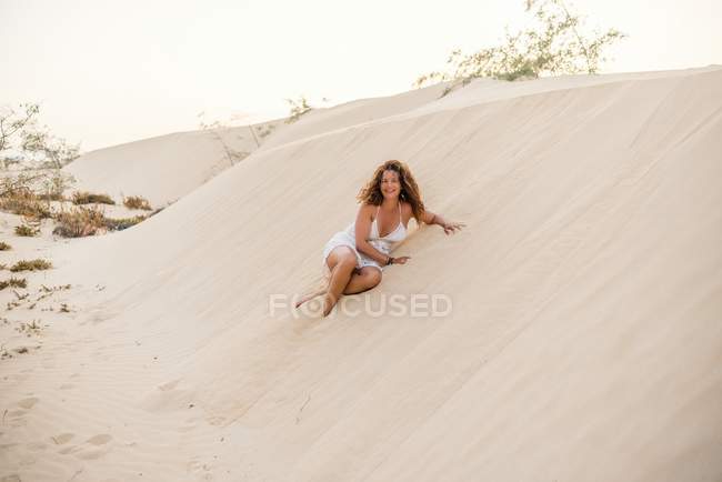 Женщина сидит на песке в пустыне — стоковое фото