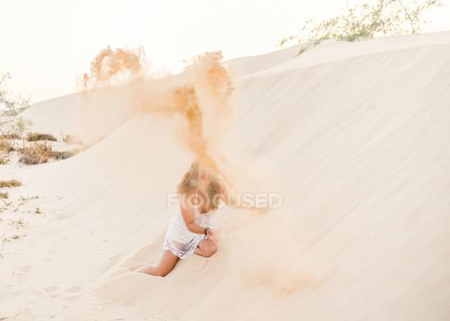 Relaxed funny woman lying in sand and throwing up sand in shore in Fuerteventura, Las Palmas, Spain — Stock Photo