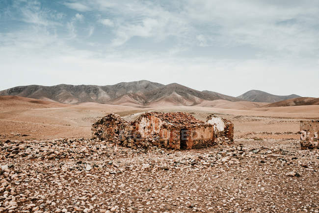 Edifícios antigos diluídos no deserto da montanha sob céu nublado — Fotografia de Stock