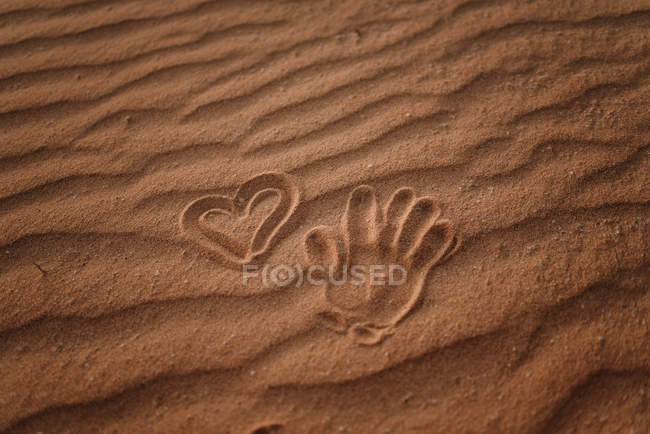Impresión manual en arena y signos cardíacos desde arriba en Fuerteventura, Las Palmas, España - foto de stock