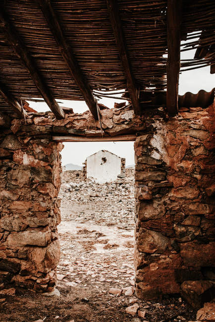 Einfache tür der alten unbewohnten konstruktion mit zugang zum weißen alten haus in fuerteventura, las palmas, spanien — Stockfoto