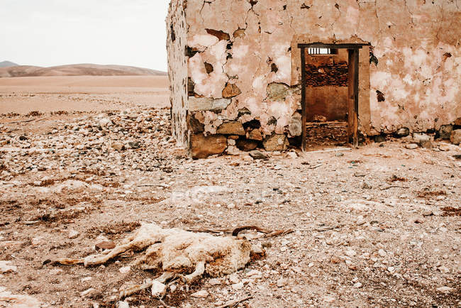 Bâtiments anciens dilatés dans le désert de montagne sous un ciel nuageux — Photo de stock