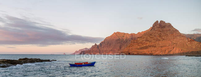 Blue sailboat in sea and beautiful rocks — Stock Photo