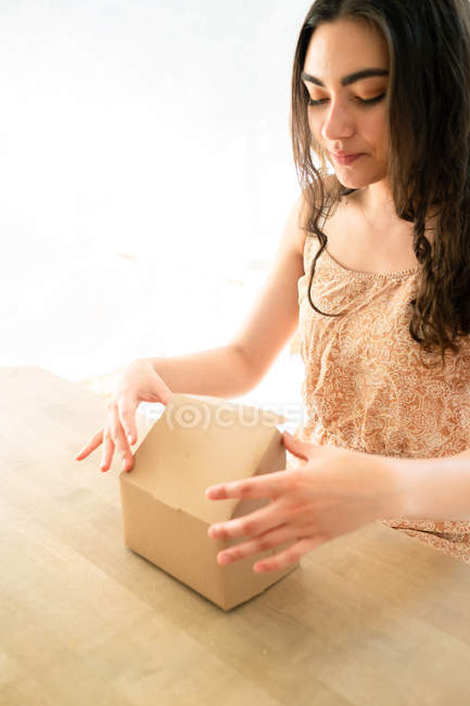 Mulher feliz em sundress com caixa de refeição sentada à mesa — Fotografia de Stock