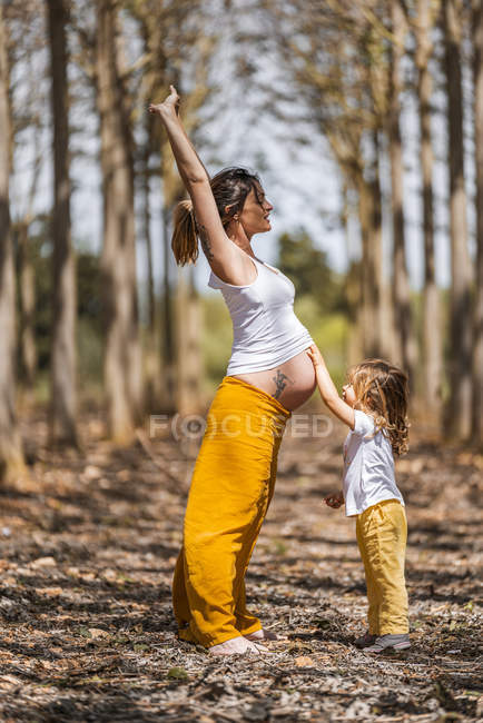 Schwangere Mutter und kleine Tochter amüsieren sich im Park — Stockfoto