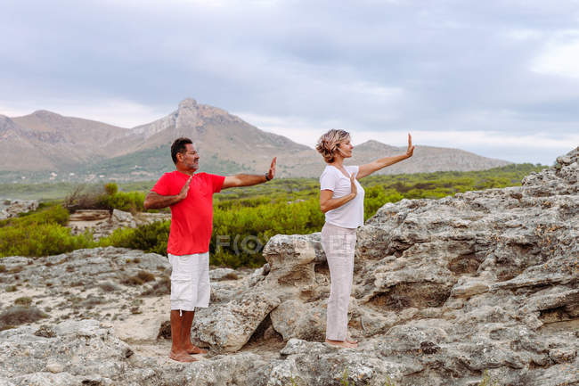Couple méditant sur le rocher — Photo de stock