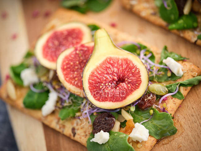Sanduíche caseiro aberto com fatias de figo e queijo em pão de centeio com salada de foguete, close-up — Fotografia de Stock