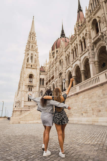Funny girlfriends on old square with dome buildings — Stock Photo