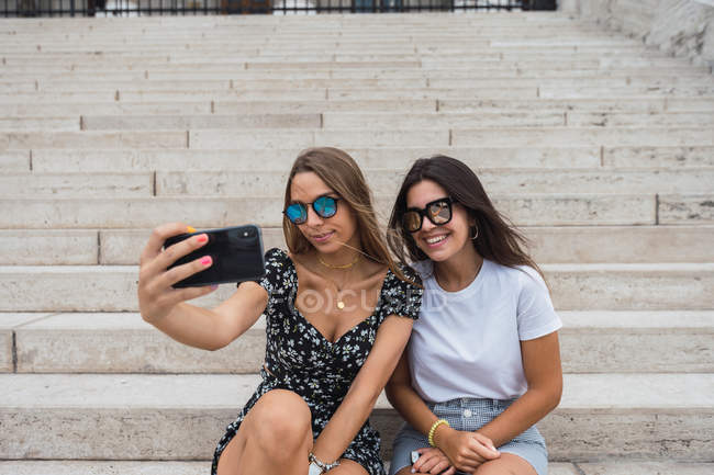 Rindo mulheres tomando selfie nas escadas no edifício velho — Fotografia de Stock