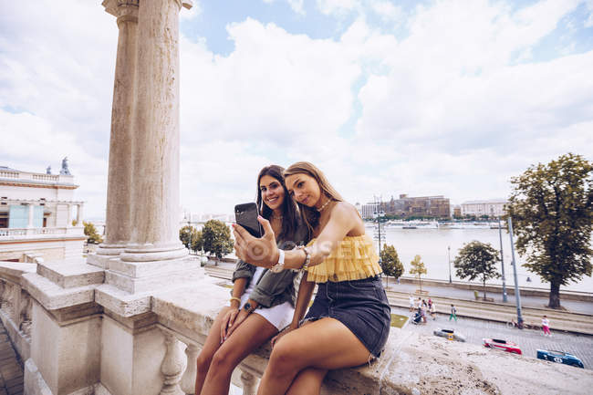 Les femmes riantes prennent selfie sur le vieux bâtiment — Photo de stock